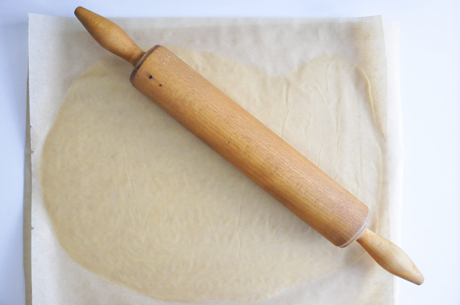 przygotowanie ciasta kruchego na tartaletki, wałkowanie pomiędzy dwoma arkuszami papieru do pieczenia