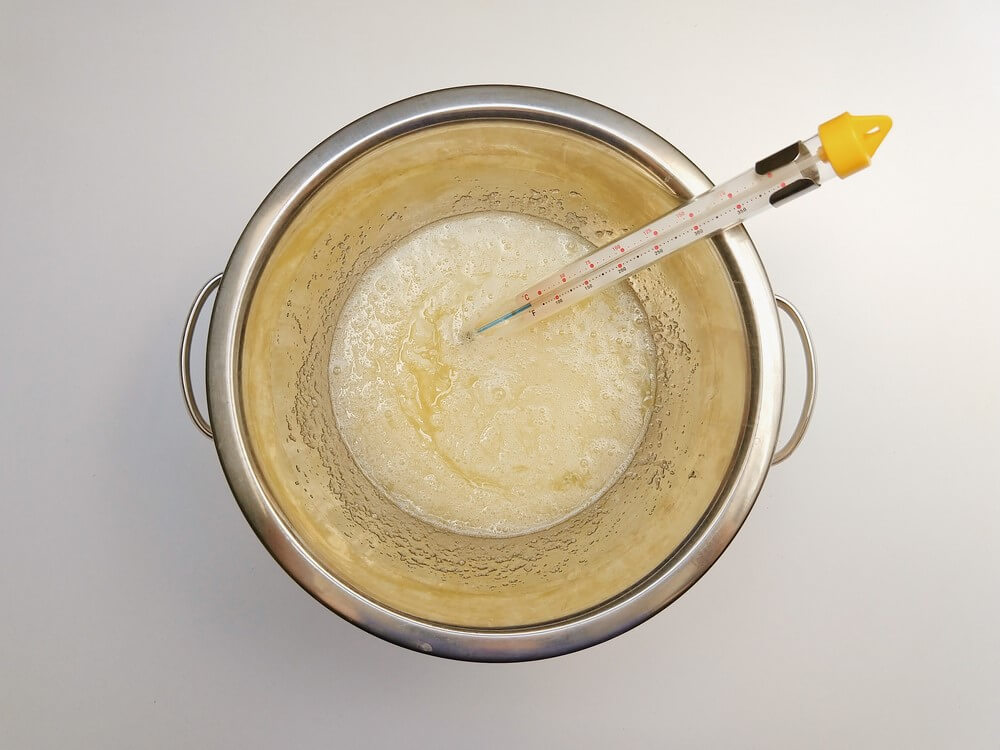 przygotowanie kremu maślanego na bezie szwajcarskiej, podgrzewanie białek z cukrem, miska, garnek, termomemetr cukierniczy