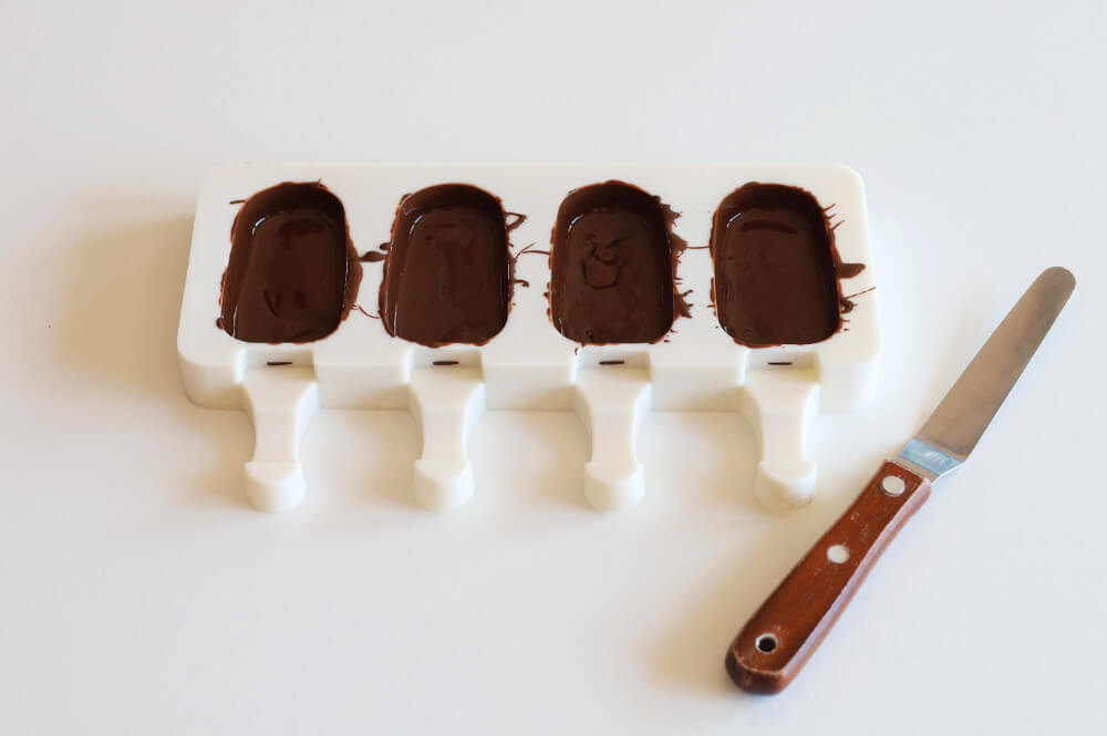 wypełnianie formy na cakesicles temperowaną czekoladą