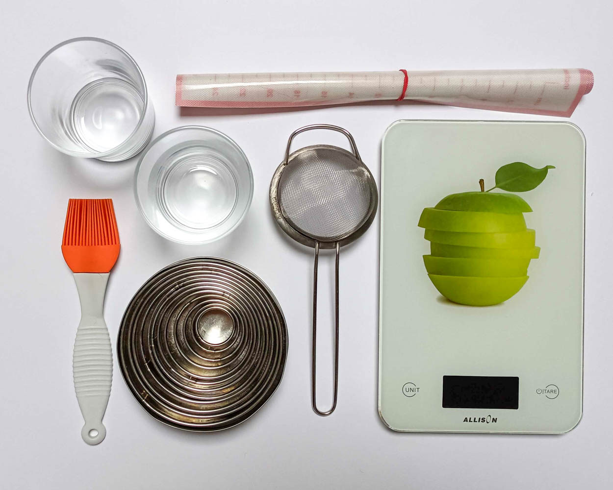 narzędzia do przygotowania pistacjowego tiramisu - waga kuchenna, sitko, mata silikonowa, pędzel silikonowy, szklaneczki lub słoiczki, okrągłe wykrawacze